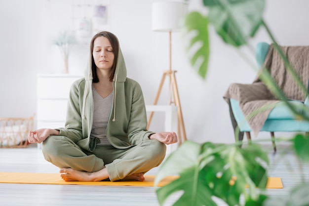 Méditation et yoga à la maison belle et jeune femme européenne faisant du yoga