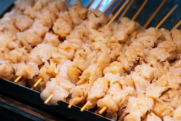 Méduse fraîche sur une brochette en bois pour barbecue grillé, marché de la nourriture de rue thaï