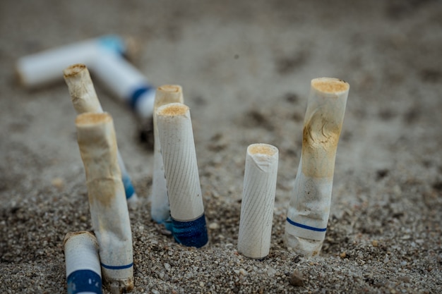 Mégots de cigarettes après utilisation, puis laissés sur le sable