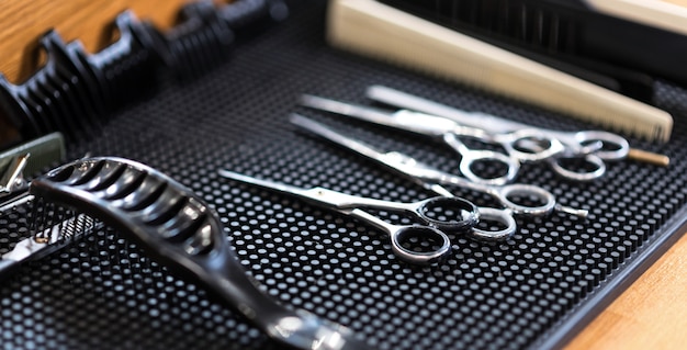 Meilleur équipement. Vue latérale des ciseaux en métal brillant et brosse à cheveux allongé sur la table en salon de coiffure.