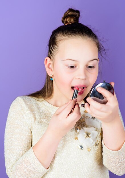 Le meilleur traitement de soin des lèvres Mignon petit enfant appliquant un bâton de soin des lèvres Adorable fille prenant soin de ses lèvres Petit modèle de beauté occupé avec la routine essentielle de soin des lèvres