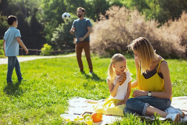 Meilleure mère. Joyeuse mère aimante assise avec sa fille et son mari jouant avec leur fils