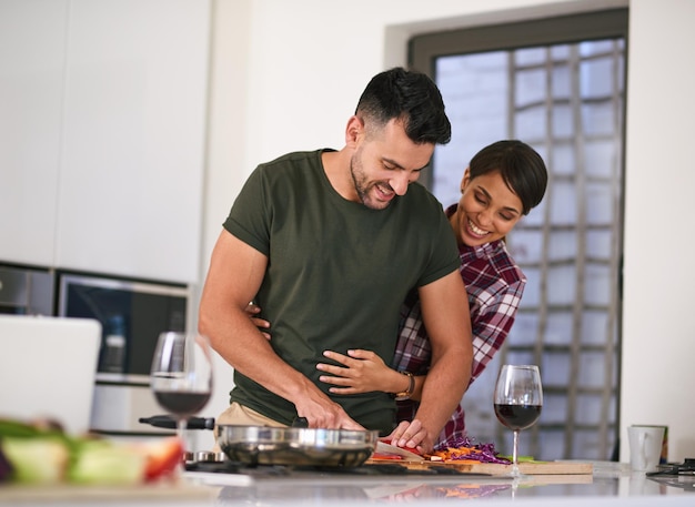 La meilleure nourriture est faite ensemble Photo recadrée d'un jeune couple séduisant cuisinant ensemble dans la cuisine à la maison