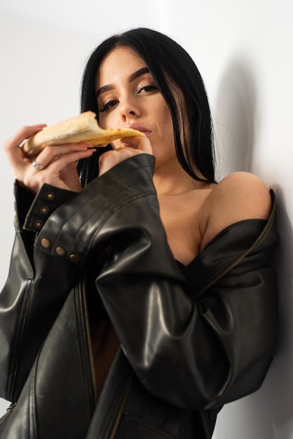 La meilleure nourriture se mange avec les mains. Une femme sensuelle mord une tranche de pizza. Jolie fille mange des aliments cuits au four. Menu pizzéria. Pizzeria. Style de cuisine italienne. Déguster de délicieuses pizzas. Le temps passe vite quand vous mangez.