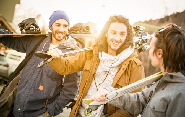 Meilleurs amis s'amusant ensemble à marcher avec du ski et du snowboard lors d'un voyage en montagne