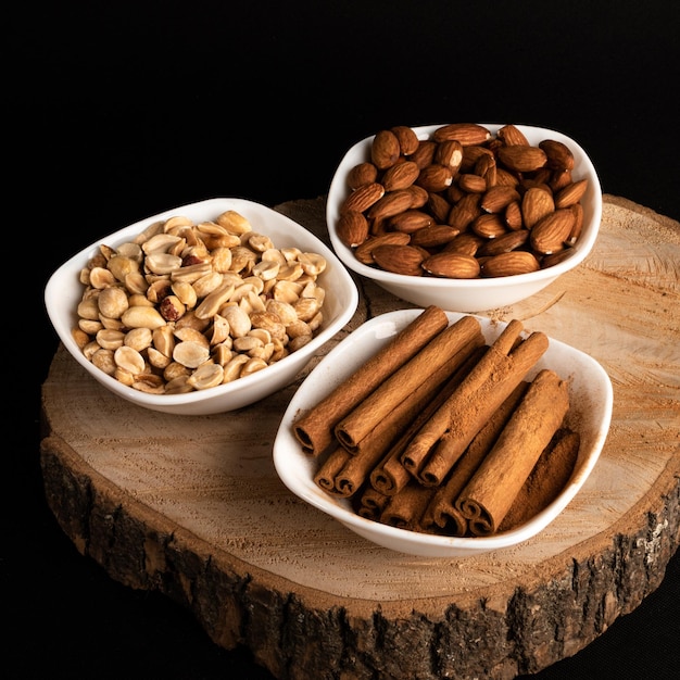 Mélange d'arachides et d'amandes à la cannelle sur fond de bois