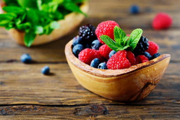 Mélange de baies d'été et de menthe sur la table en bois