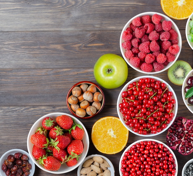 Mélange de baies fraîches, de noix et de fruits sur fond de bois