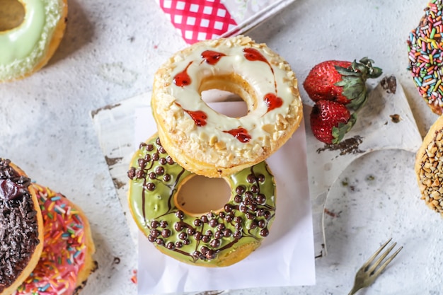 Mélange de beignets sucrés multicolores avec des paillettes colorées