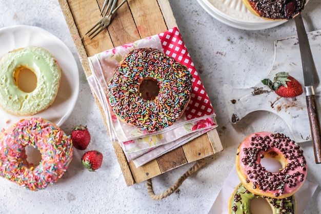 Mélange de beignets sucrés multicolores avec des paillettes colorées