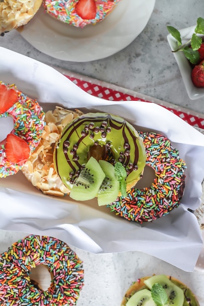 Mélange de beignets sucrés multicolores avec des paillettes colorées