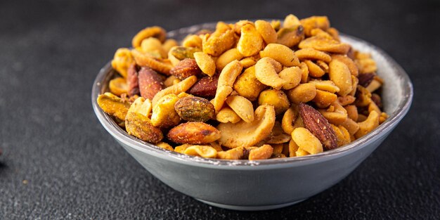 mélange de collations au sel de noix amandes, noix de cajou, pistaches, arachides noix fraîches aliments sur la table copie espace aliments