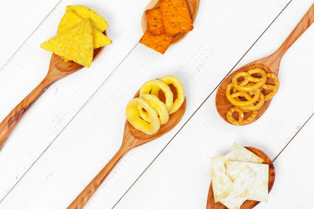 Mélange de collations: bretzels, craquelins, chips et nachos sur la table