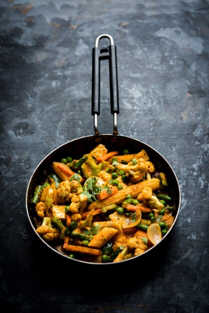 Mélange de curry de légumes - La recette du plat principal indien contient des carottes, du chou-fleur, des pois verts et des haricots, du maïs miniature, du poivron et du paneer ou du fromage cottage avec du masala traditionnel et du curry