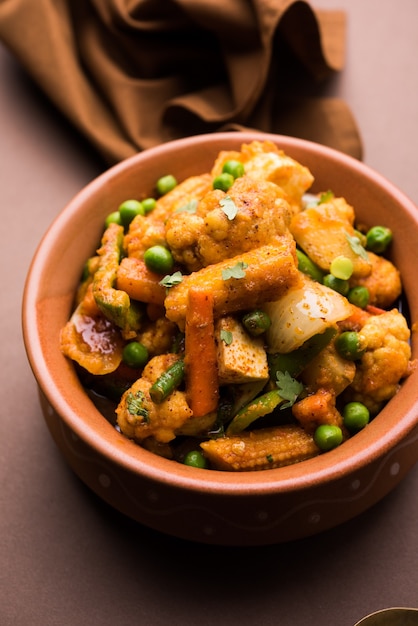 Mélange de curry de légumes - La recette du plat principal indien contient des carottes, du chou-fleur, des pois verts et des haricots, du maïs miniature, du poivron et du paneer ou du fromage cottage avec du masala traditionnel et du curry