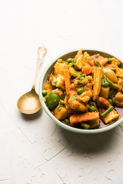 Mélange de curry de légumes - La recette du plat principal indien contient des carottes, du chou-fleur, des pois verts et des haricots, du maïs miniature, du poivron et du paneer ou du fromage cottage avec du masala traditionnel et du curry