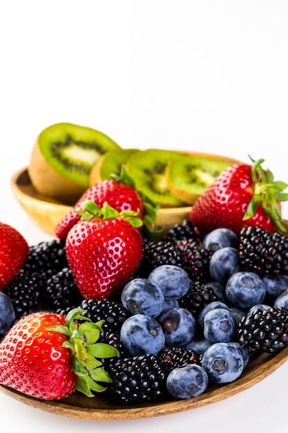 Mélange de fruits frais biologiques dans un bol en bois sur la table.