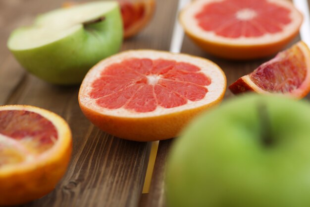 Mélange de fruits frais tranchés sur un fond en bois. Photo avec profondeur de champ.