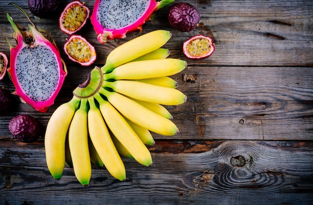 Mélange de fruits tropicaux avec banane fruit de la passion et fruit du dragon sur fond bois Vue de dessus