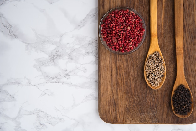 Mélange de grains de poivre séchés dans un bol en bois