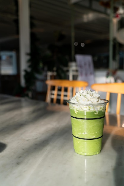 mélange de latte de thé vert matcha dans un verre avec de la crème à fouetter