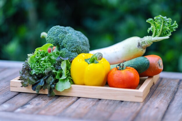 Un mélange de légumes frais dans un plateau en bois sur la table