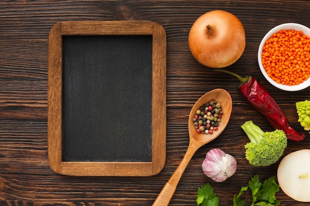 Photo mélange de légumes plats et tableau blanc