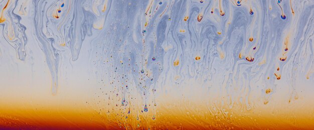 Un mélange liquide coloré mélangeant des peintures dans un fond fluide abstrait et dynamique.