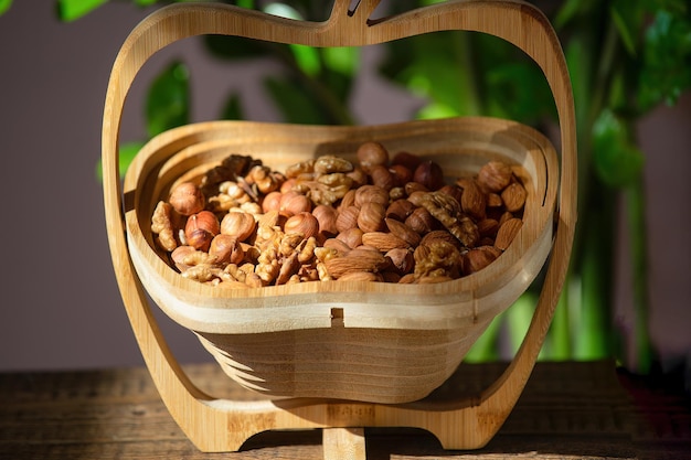 Mélange de noix dans un panier en bois sur un fond en bois