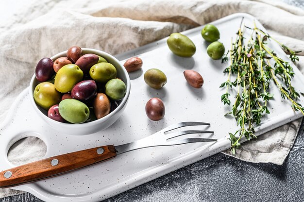 Mélange d'olives salées colorées avec un os. Fond gris. Vue de dessus