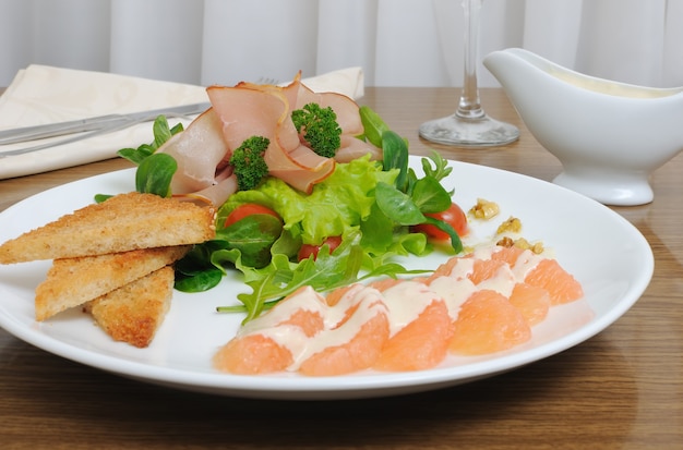 Mélange de salade avec tomates cerises et jambon avec, toast à la crème de pamplemousse