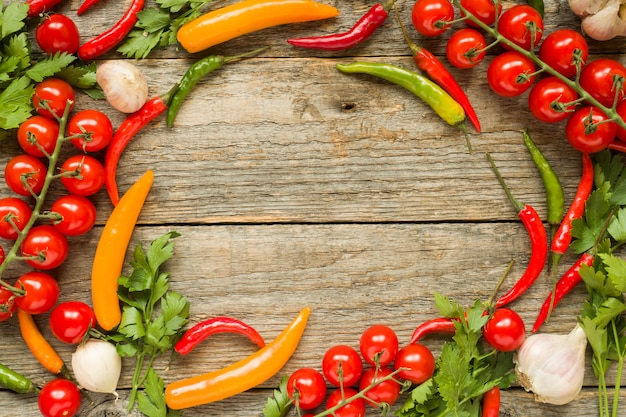 Mélange de tomates cerises au piment rouge sur une branche d&#39;ail et d&#39;autres épices sur un fond d&#39;espace de copie en bois