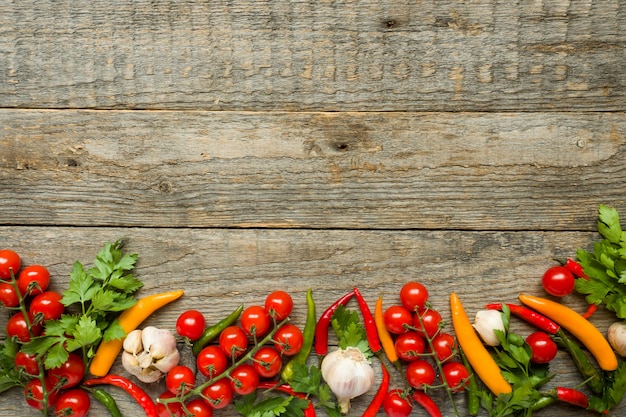 Mélange de tomates cerises au piment rouge sur une branche d&#39;ail et d&#39;autres épices sur un fond d&#39;espace de copie en bois