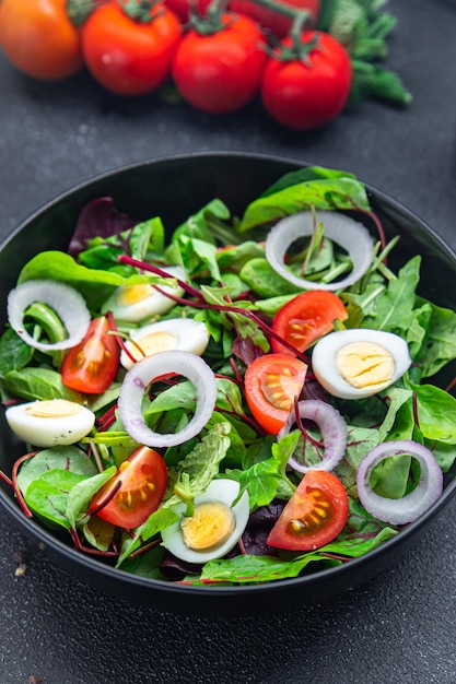 Mélange de tomates et d'oeufs de caille à salade feuilles de légumes repas sains collation alimentaire sur la table copie espace nourriture