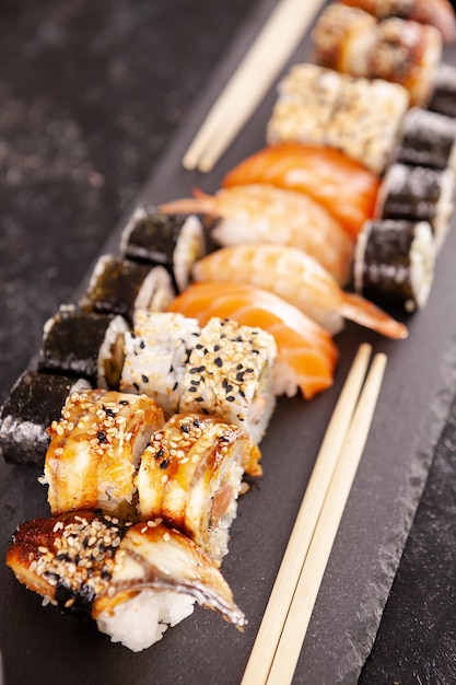 Mélange de variétés de rouleaux de sushi sur fond noir en photo de studio