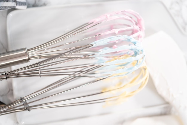 Mélanger du colorant alimentaire dans la meringue pour cuire des biscuits à la meringue licorne.