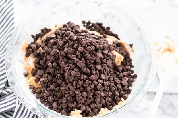 Mélanger les ingrédients dans un bol en verre pour cuire des biscuits aux pépites de chocolat.