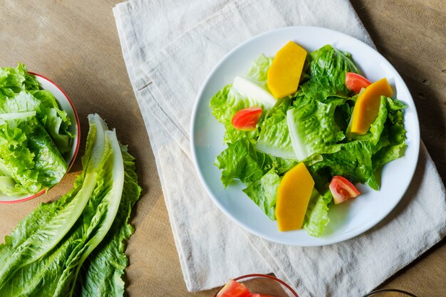 Mélanger les légumes à salade dans un plat blanc, végétalien