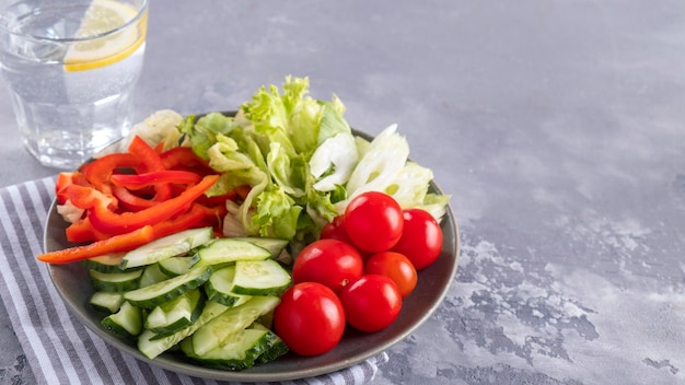 Mélanger les légumes avec les tomates, les concombres, le céleri et le poivron rouge sur une assiette Concept de régime alimentaire et d'aliments sains Copier l'espace