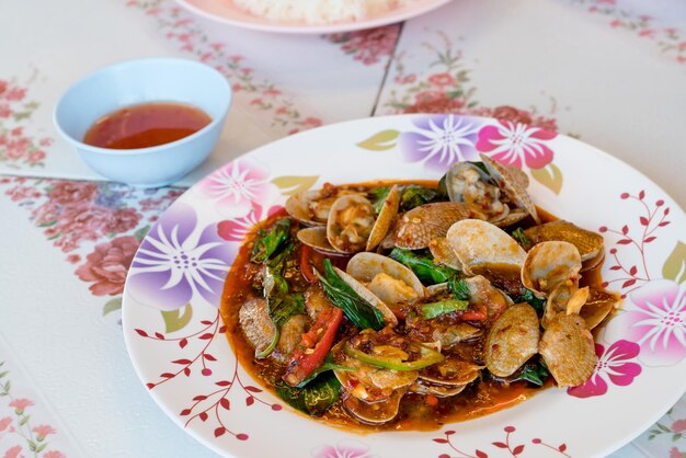 Mélanger des palourdes frites avec de la pâte de chili rôtie sur la tableMange thaïlandaise