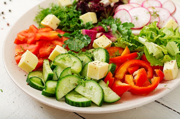 Mélanger la salade de légumes frais et d'herbes vertes.