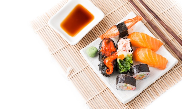 Mélanger les sushis sur plat blanc isolé