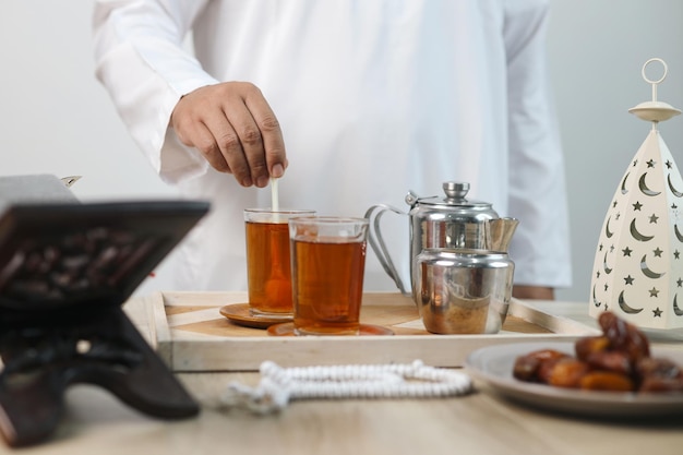 Mélanger le thé avec du sucre à la main Préparer des boissons sucrées pour l'Iftar du Ramadan