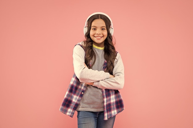 mélomane écouter de la musique sans fil casque dispositif accessoire nouvelle technologie développement de l'enfance enfant dans des écouteurs modernes éducation en ligne retour à l'écoleheureuse adolescente dans un casque