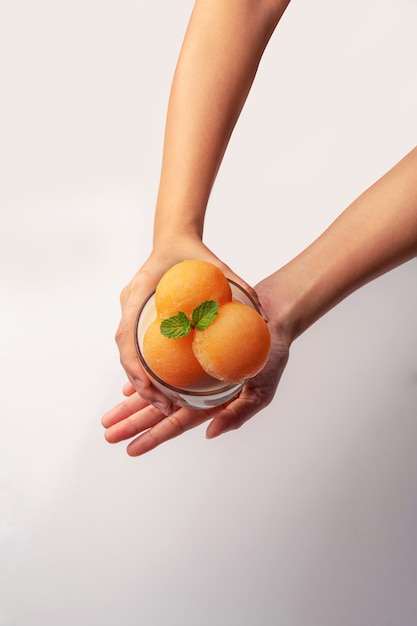 Melon à chair jaune a été versé dans une boule ronde comme de la crème glacée. Mettre dans un verre transparent garni de lait frais, sucré et délicieux.