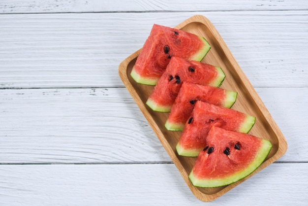 Melon d'eau fraîche tranchée sur du bois blanc