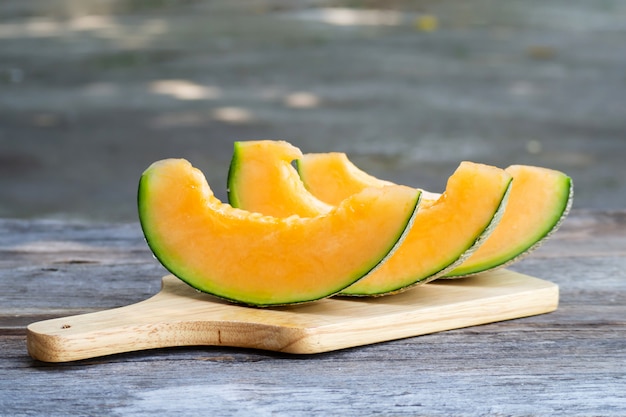 Melon frais en tranches sur une planche de bois. Fruit sucré