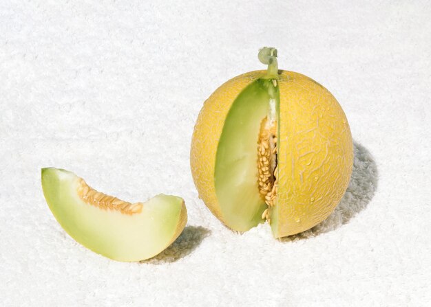 Melon jaune cru frais ou cantaloup sur serviette blanche concept de régime alimentaire Idée minimale de fruits d'été