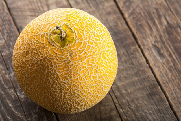 Melon jaune mûr sur fond de bois