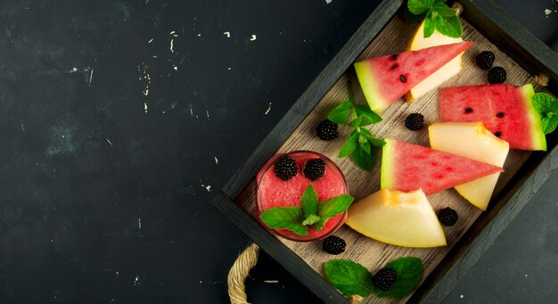 Melon, melon d'eau, mûres et menthe sur un plateau